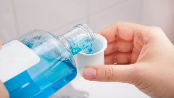 Person Pouring Liquid In Container Enjuagues bucales o colutorios