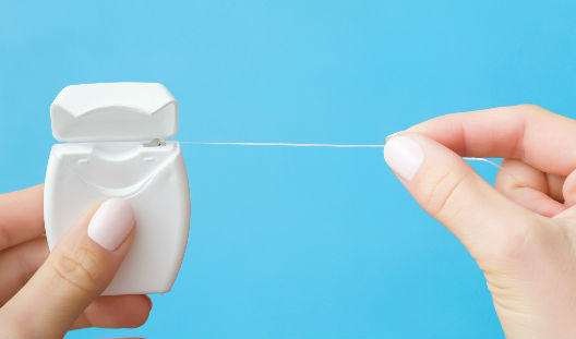 uso del hilo dental importancia persona haciendo uso del hilo dental