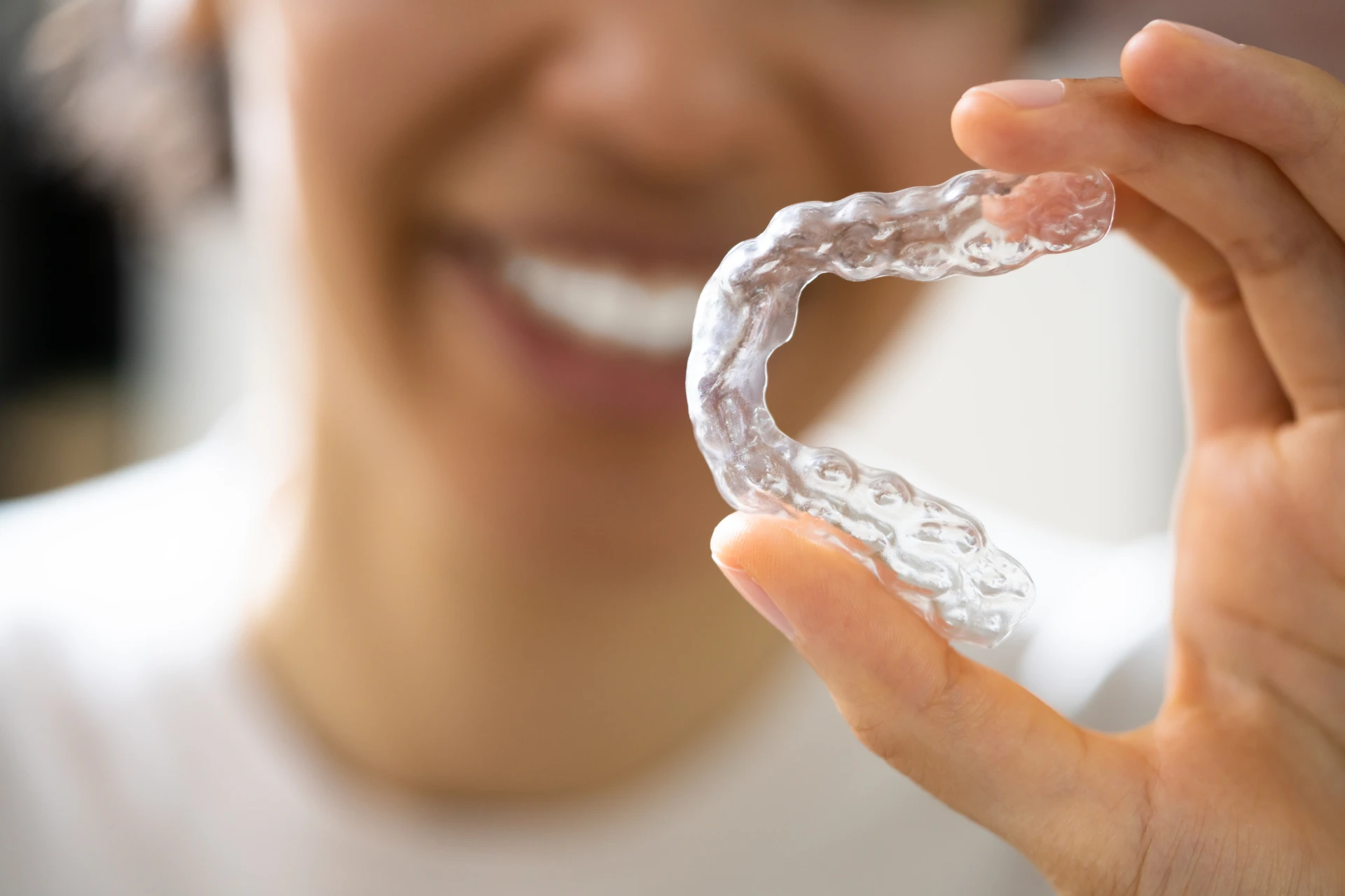 Chica mostrando alineadores transparentes